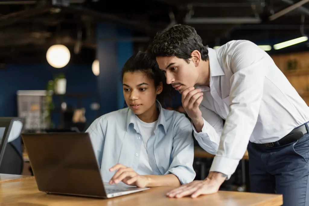Male and female coworkers at the office working with laptop.