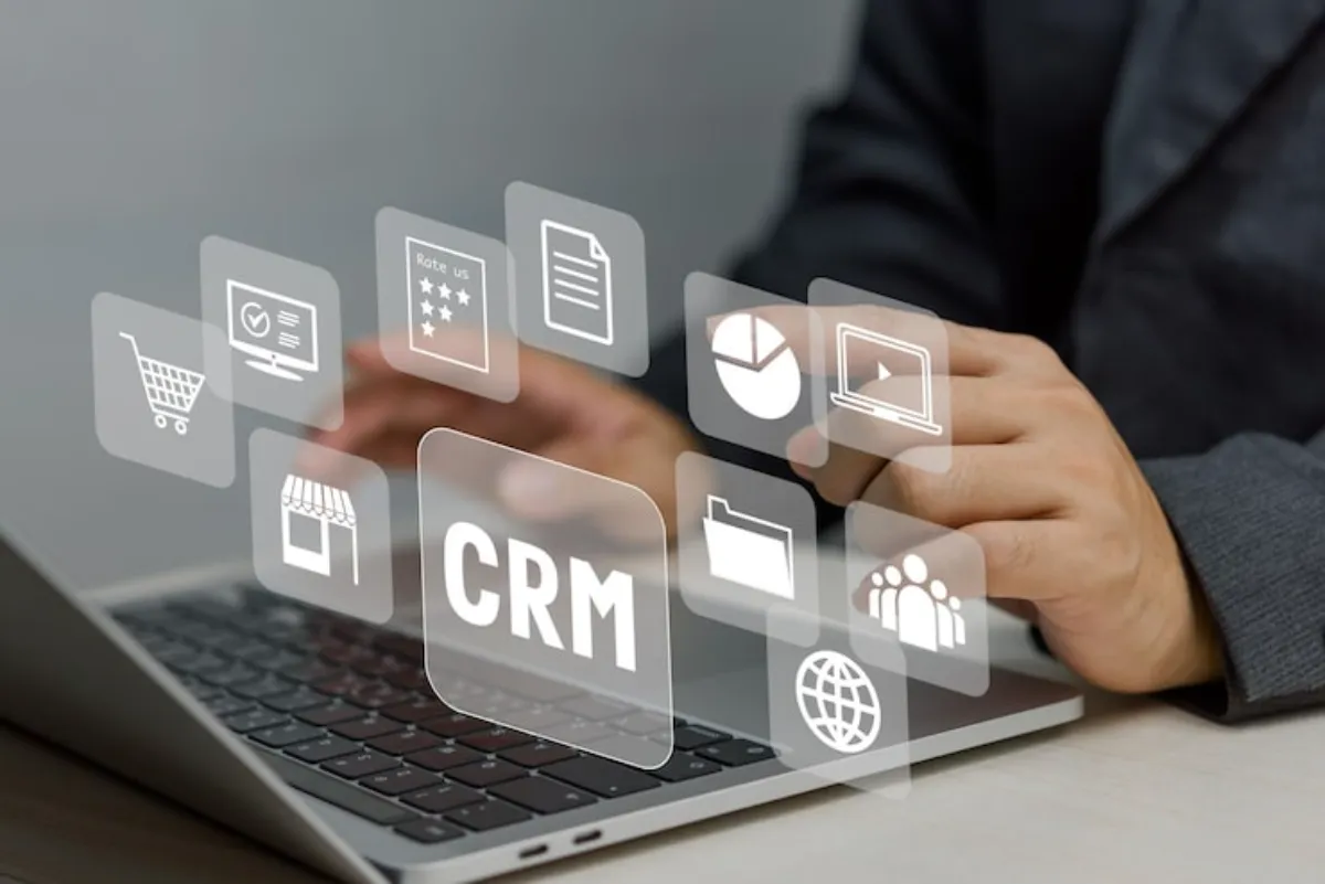 Custom CRM represented by a professional using a laptop with connected customer data, documents, analytics, and business tools